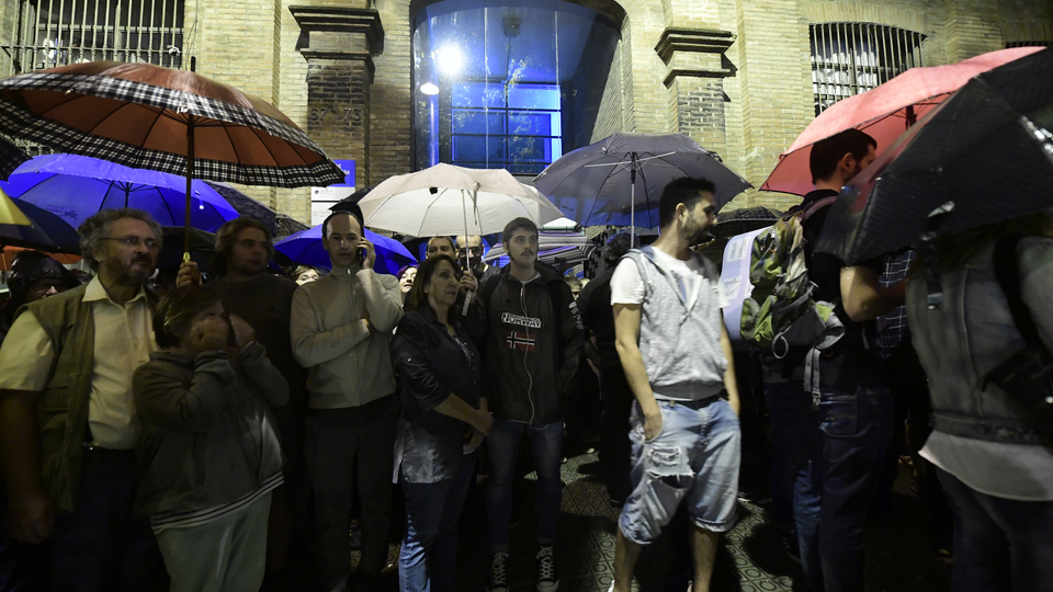 People gather outside a polling station in Barcelona, on October 1, 2017, to prevent the police to seal it off in a referendum on independence for Catalonia banned by Madrid. Madrid has vowed to stop the referendum from going ahead, closing polling stations, seizing millions of ballot papers, detaining key organisers and shutting down websites promoting the vote. (AFP)