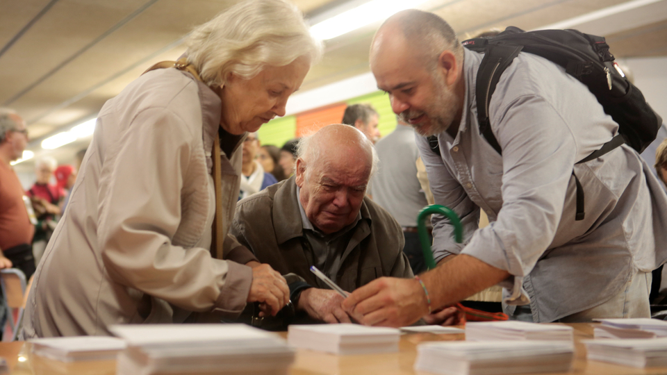 An old man reacts as he picks up a ballot inside a polling station for the banned separatist referendum in Barcelona, Spain October 1, 2017. (Reuters)