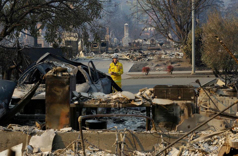 An official from Cal Fire department inspects damage at homes destroyed by fires in Santa Rosa, California, Thursday, Oct. 12, 2017.
