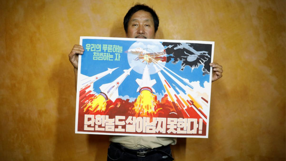 Head of Gallery Pyongyang showcases an example of North Korean propaganda art reading 