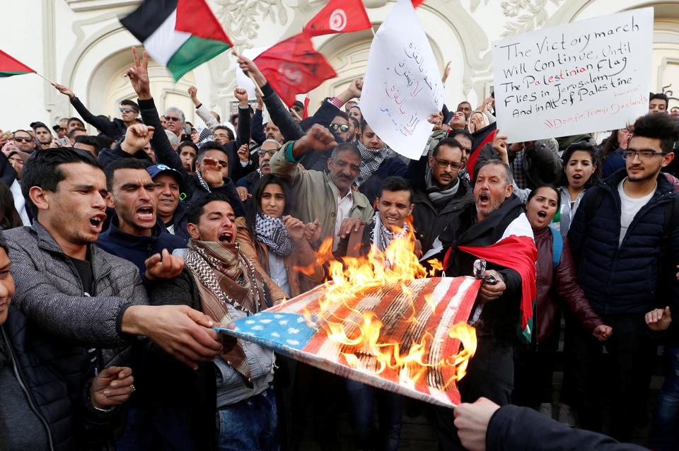 Protesters burns a U.S. flag during a protest against Trump's decision to recognise Jerusalem as the capital of Israel, in Tunis, Tunisia, on December 7, 2017.