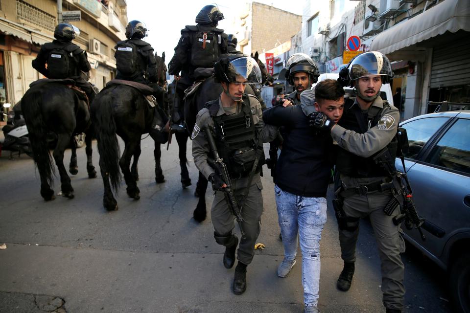 Israeli border police officers detain a protestor during a demonstration in a street in east Jerusalem